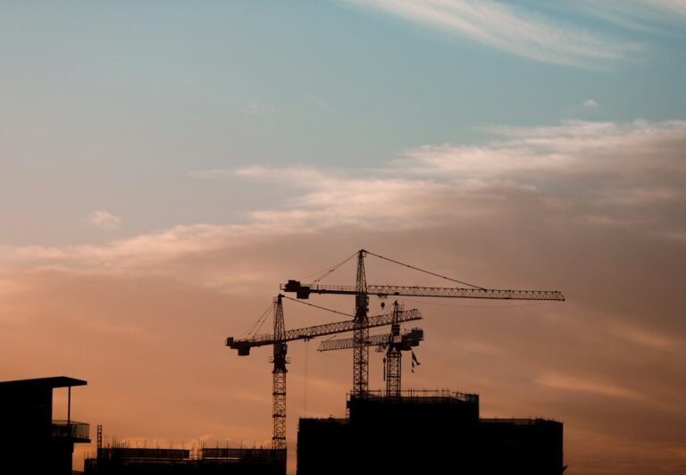 Construction cranes at sunset